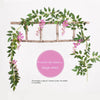 A silk wisteria vine garland with purple-pink flowers draped over a wooden trellis.