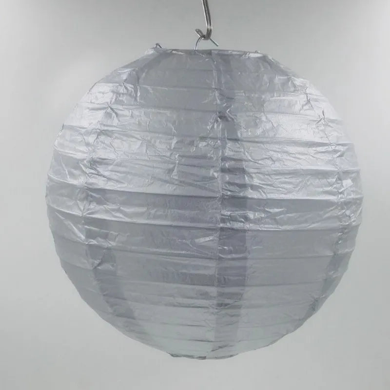 A round, silver foil paper lantern hanging, used for parties or weddings.