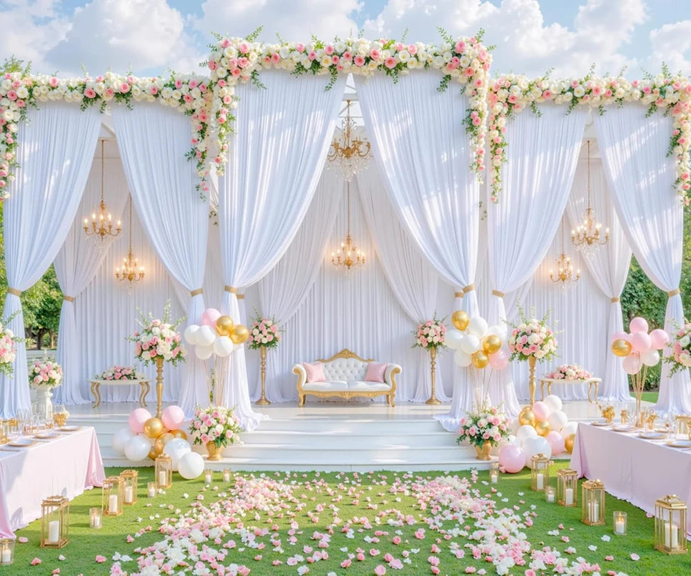 A white fabric backdrop curtain decorated with pink and white flowers and draped fabric for an event.