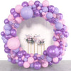 A balloon garland featuring shades of purple and pink balloons with gold accents.
