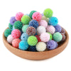A pile of colorful textured resin beads in various shades of green, pink, purple, and blue.