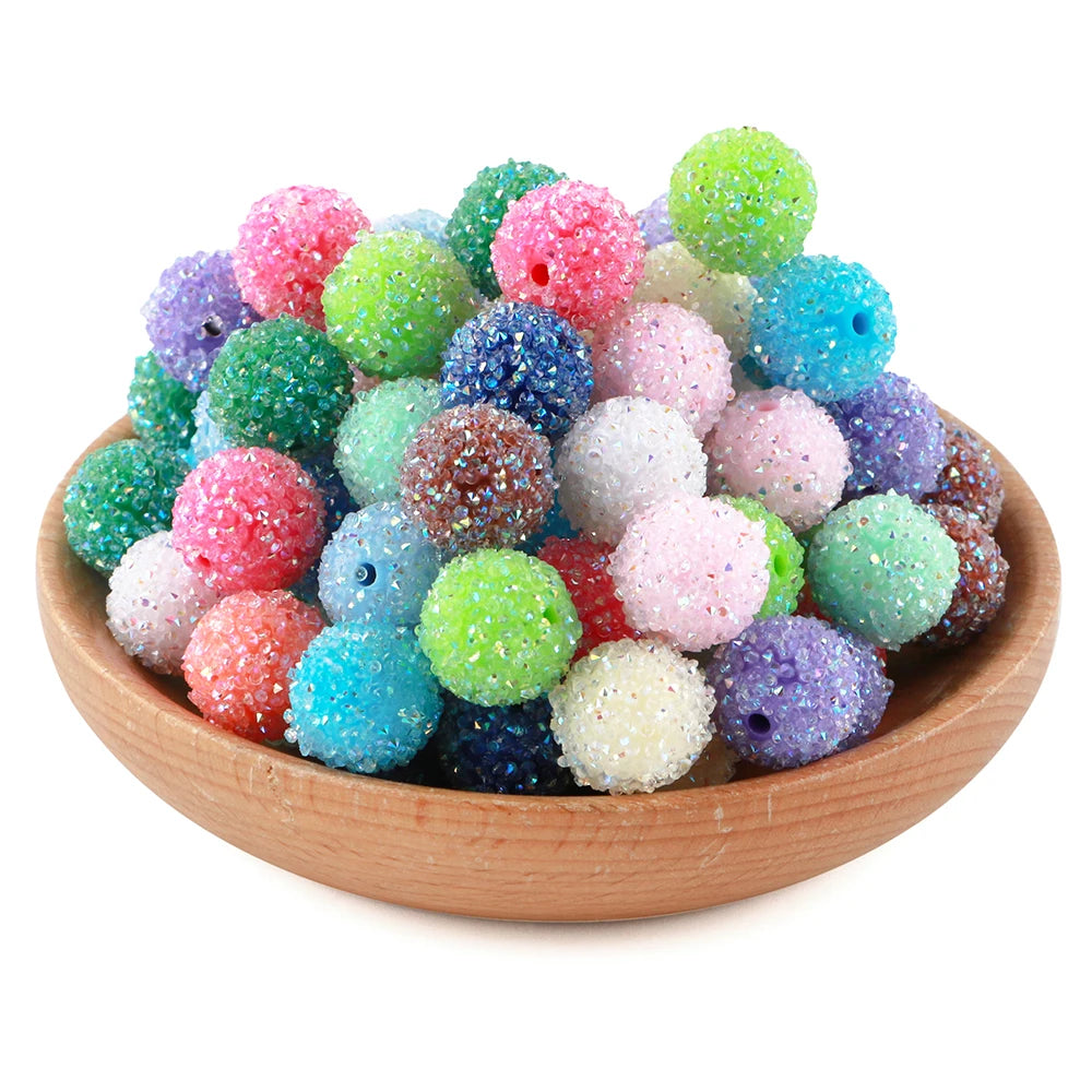 A pile of colorful textured resin beads in various shades of green, pink, purple, and blue.