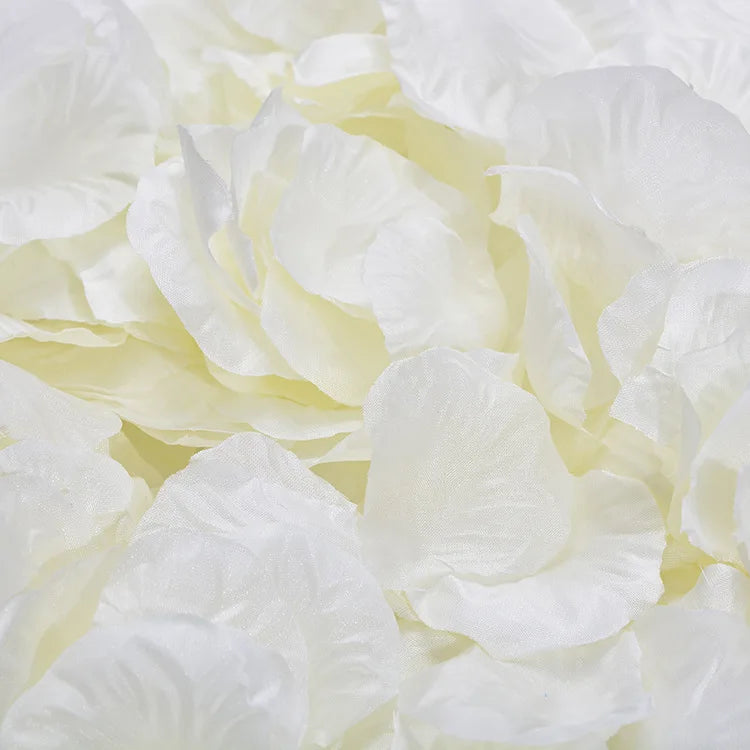 Gros plan de pétales de roses artificielles blanches et crème utilisés pour la décoration.