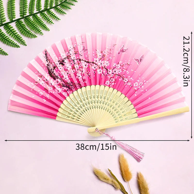 Pink and white striped bamboo folding hand fan with pink blossoms and a tassel