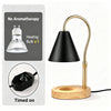 A black flameless candle warmer lamp with a gold finish and wooden base, shown next to its components.