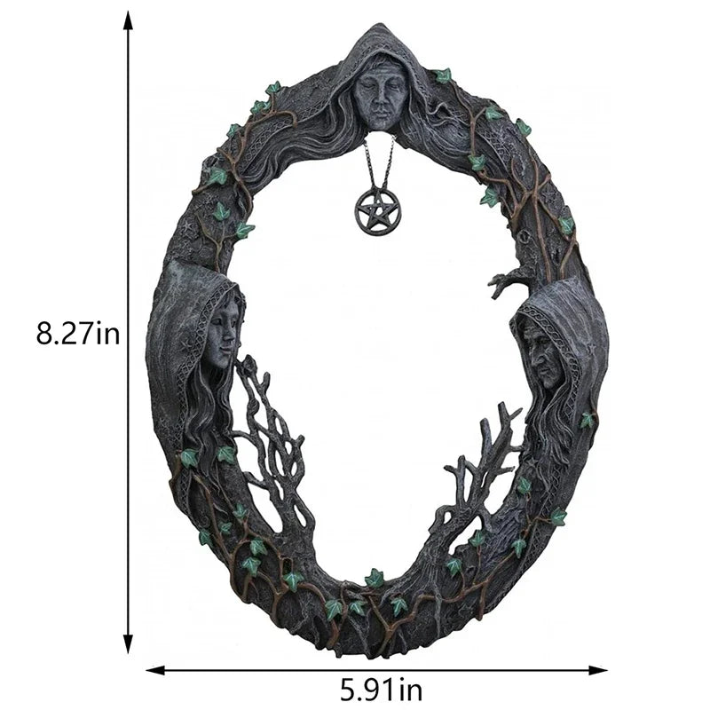 A dark, wreath-like wall hanging featuring a face and branches, with a pentagram amulet hanging from the top.