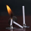 A lit white cotton candle wick is visible in a holder against a dark background.