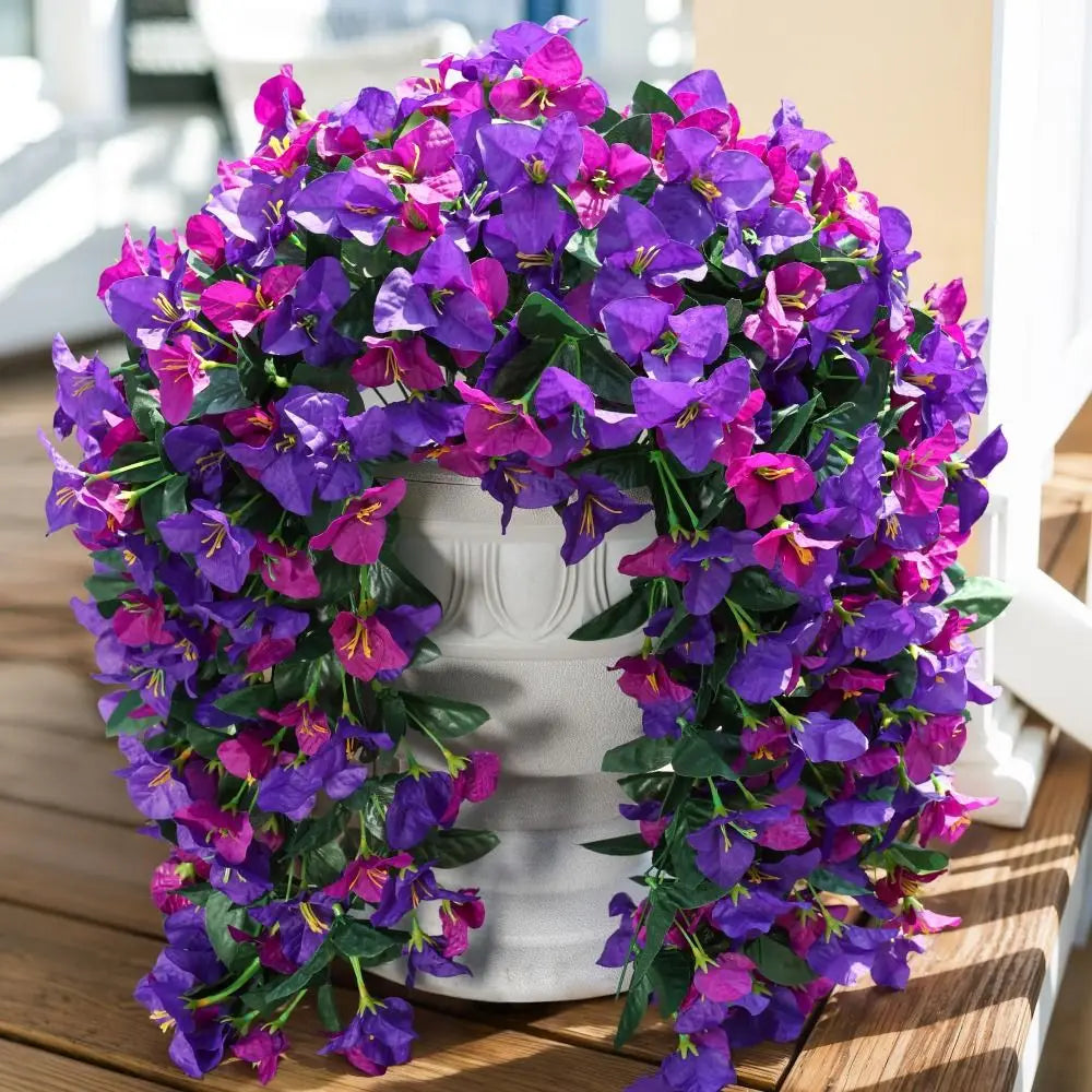 A vibrant purple and magenta faux bougainvillea vine garland displayed on a white pedestal.