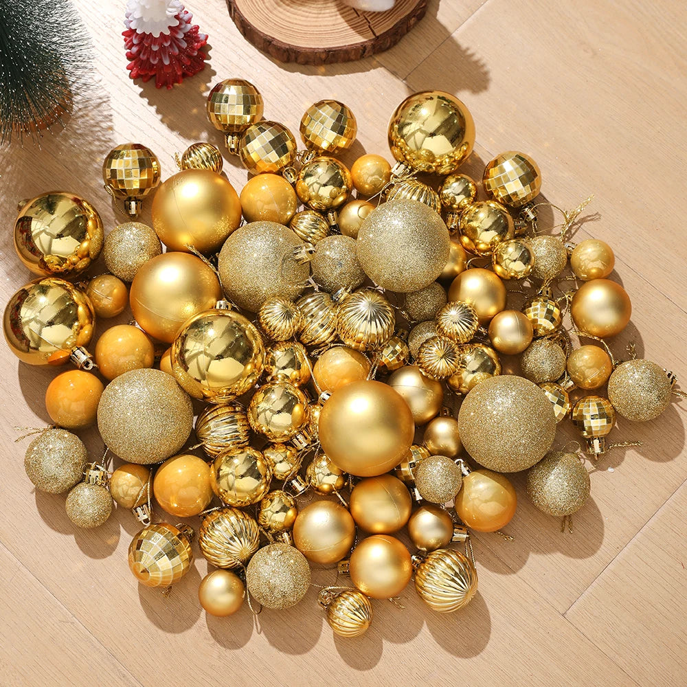Assorted gold and silver Christmas tree ornaments and pendants scattered on a light wooden surface.