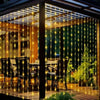 String lights drape across a wooden porch, illuminating outdoor seating and greenery.