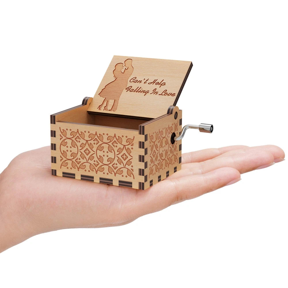 A vintage hand-cranked wooden music box featuring a cutout silhouette of a woman, engraved with the words Can't Help Falling 