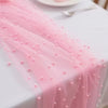 Pink pearl gauze decorative table flag with beaded trim draped on a white tablecloth.