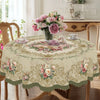 A vintage rose floral tablecloth with elegant designs is displayed on a wooden table.