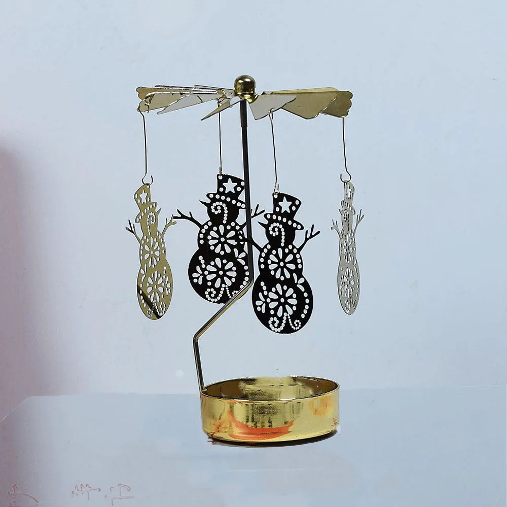 A gold rotating candle holder with a spinning carousel featuring silhouette cutouts of trees and other figures.
