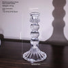 Elegant clear glass pillar candle holder with a flared base and stacked decorative elements.