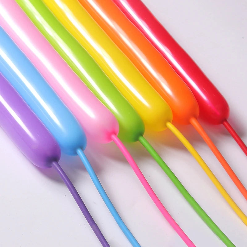 A close-up of several colorful twisting balloons in a rainbow gradient, showing various shades of pink, purple, green, yellow