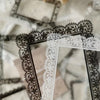 A close-up of black and white lace stickers, including a black and white floral pattern and a white lace border.