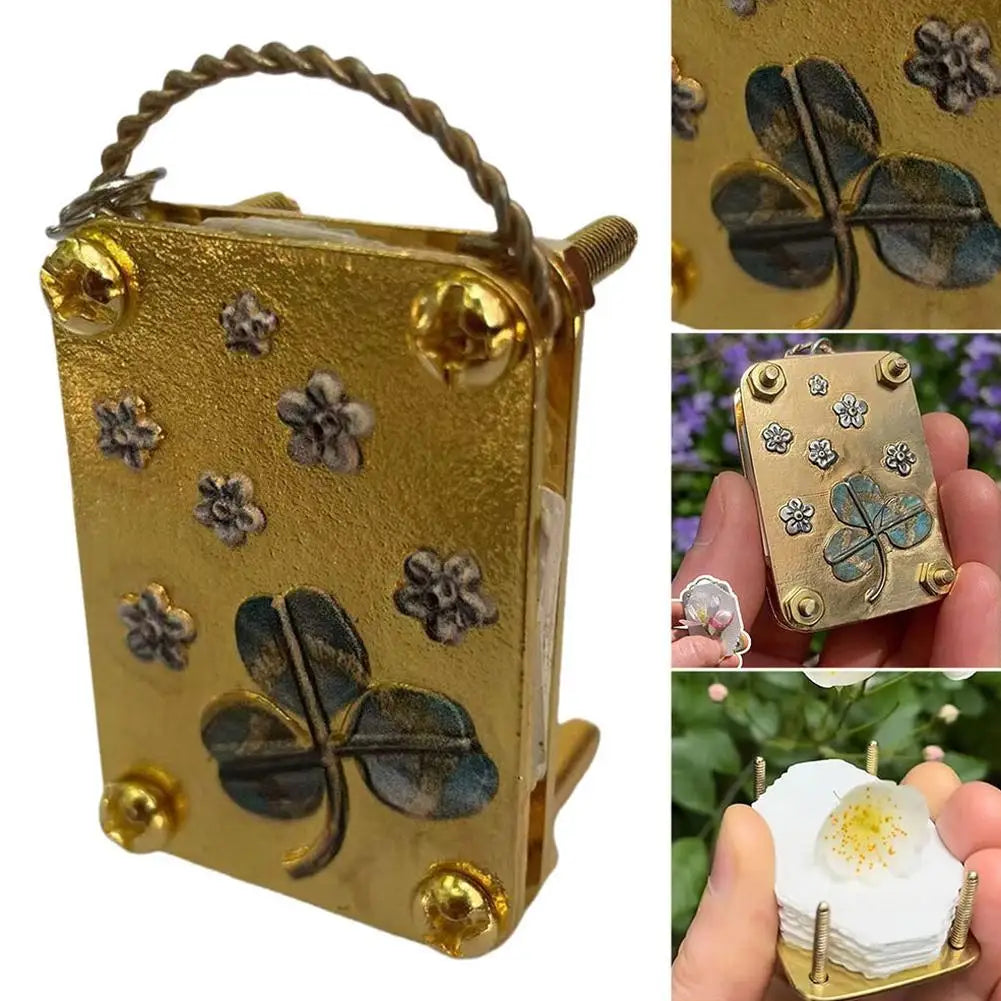 A small gold-colored metal press kit with a leaf design, used for dried flower crafts.