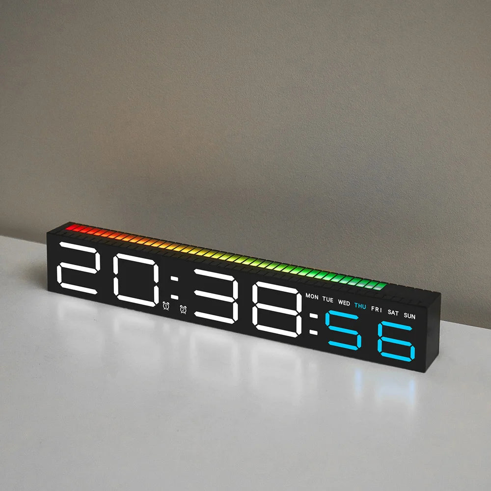 A black LED digital alarm clock displaying 20:38 and the day of the week, resting on a white surface.