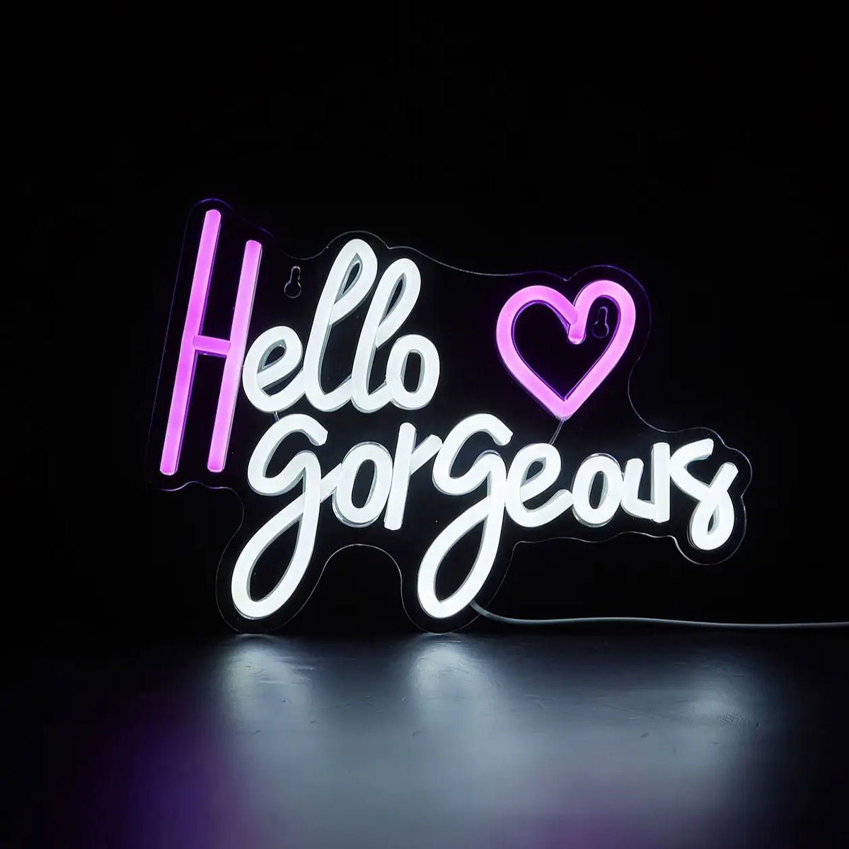 A glowing neon sign spelling out Hello Gorgeous with a heart shape on a dark background.