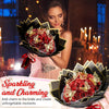 A woman holds a bouquet of red roses with gold glitter accents in an ornate black and gold presentation box.