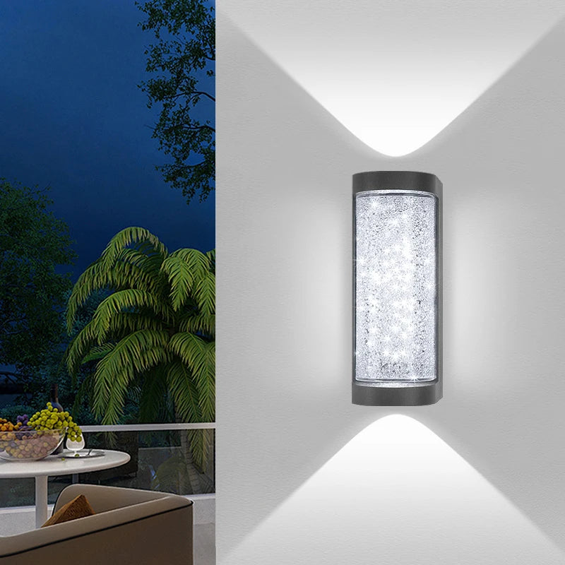 An LED crystal outdoor wall sconce with a waterproof finish mounted on a white wall, casting a bright light.