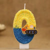 A birthday cake candle shaped like the number 0, decorated with yellow glitter and a small excavator figure on a blue base.