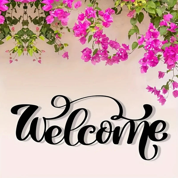 A rustic metal welcome sign featuring elegant script text surrounded by vibrant pink and green flowering vines.