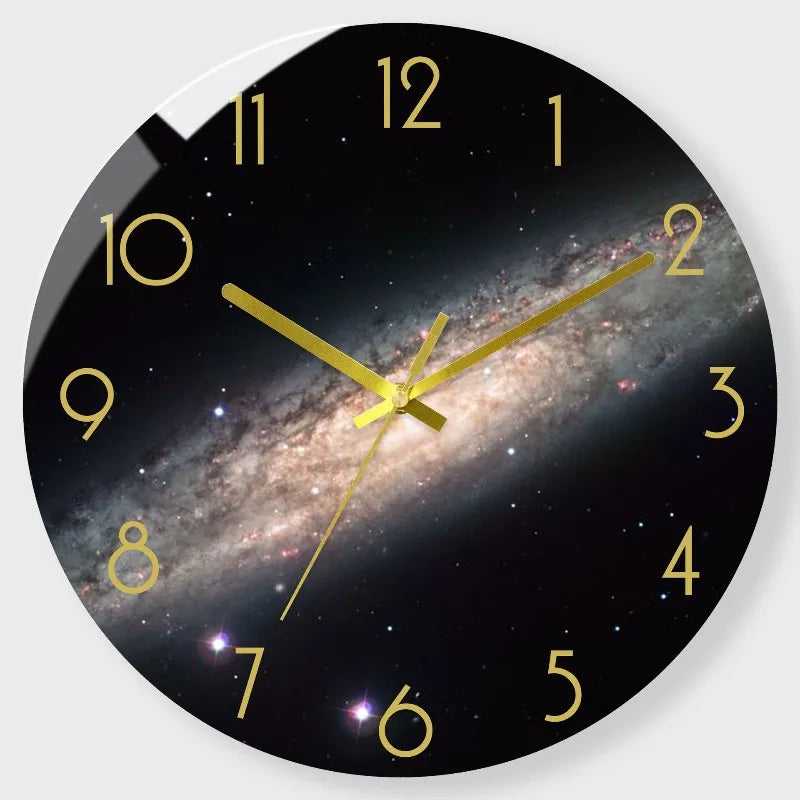 A round black wall clock face with a gold-colored hour hand pointing to two, featuring a starry night sky background.