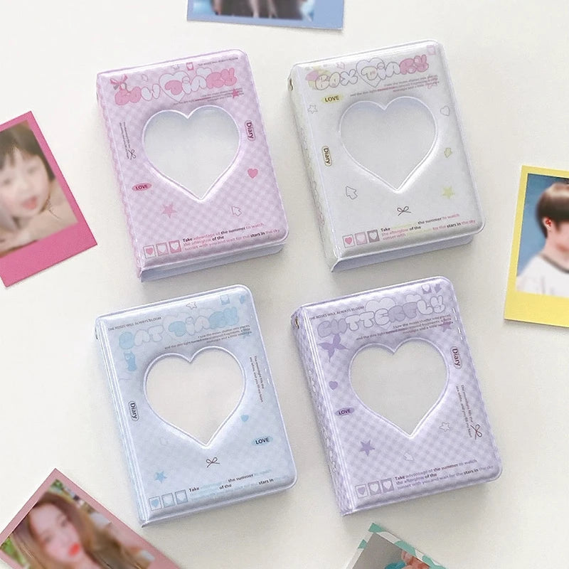 Four pink and white mini photo card album binders with heart-shaped clear windows are displayed on a white surface.