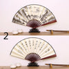 A pair of retro folding silk and bamboo decorative fans displayed on a wooden surface.