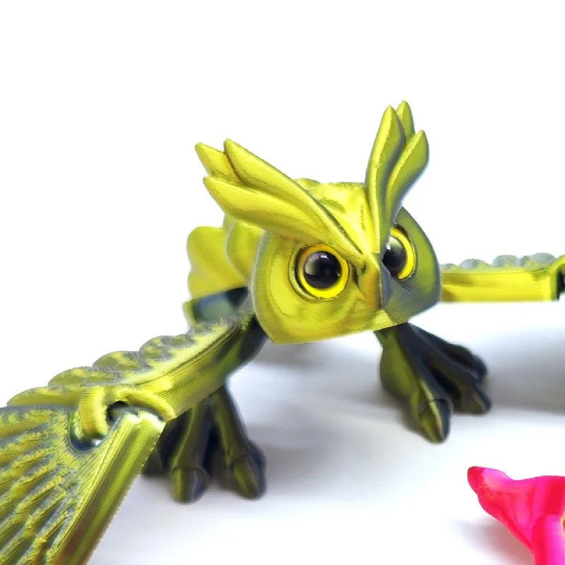 A yellow articulated 3D printed owl figurine used as desk decor.