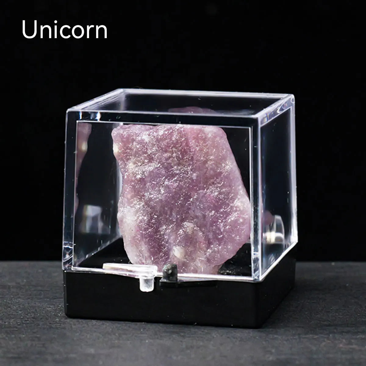 A rough, translucent purple crystal specimen is displayed inside a clear acrylic box.