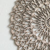 Decoración de pared de mandala de madera detallada con intrincados recortes y patrones orgánicos.