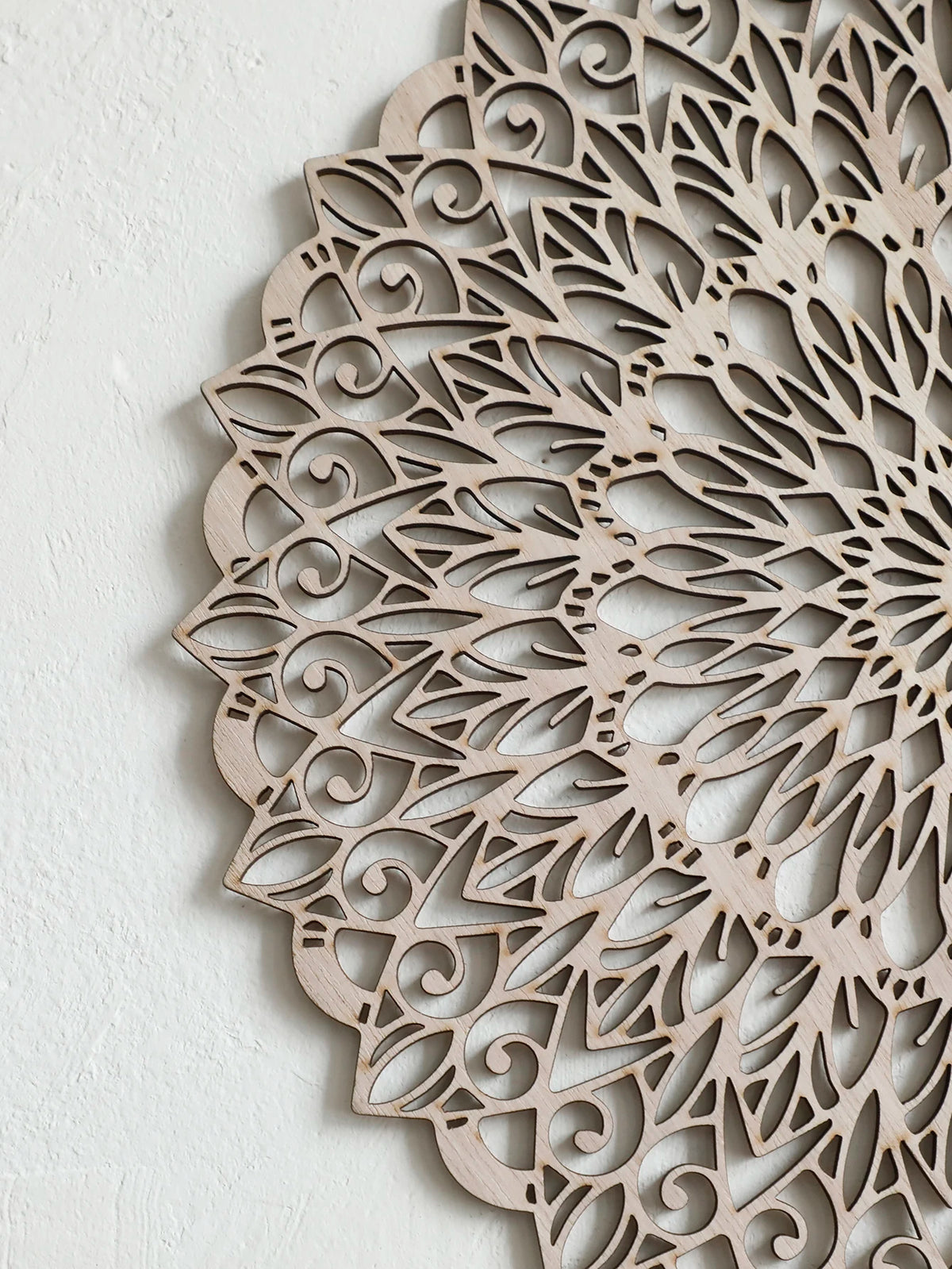 Decoración de pared de mandala de madera detallada con intrincados recortes y patrones orgánicos.