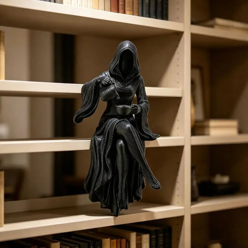 Schwarze Harzstatue einer weiblichen Figur in einem Kapuzenmantel, die einen Totenbringer darstellt, auf einem Holzregal ausg