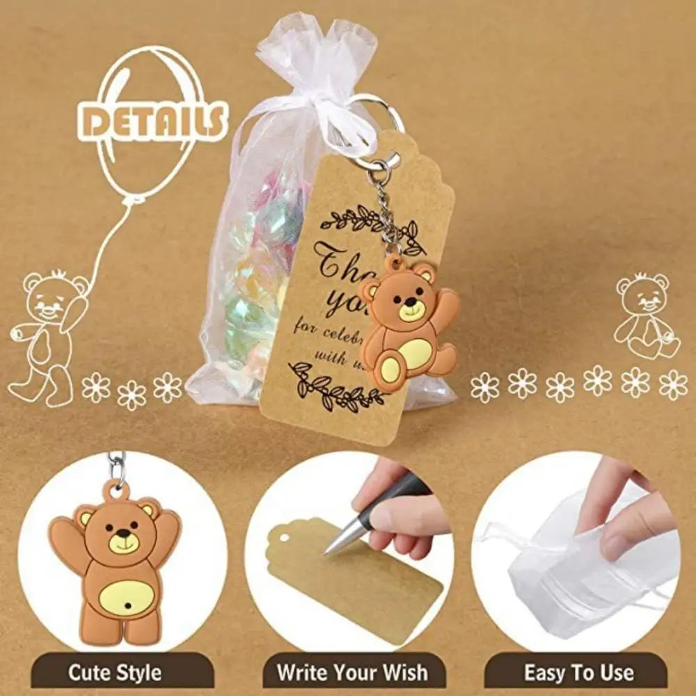 Cute bear keychain party favors with organza bags and thank you tags shown on a brown background