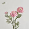 A delicate pink silk peony flower arrangement with green leaves and a bud, presented on a white background.