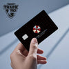 A hand holds a black card with a holographic design and the Magic Shark logo visible on the background.
