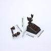 A vintage rotary desk phone miniature decor with a dark bronze finish and a white cord.