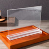 Clear acrylic double-sided tabletop sign holder with an orange wooden base