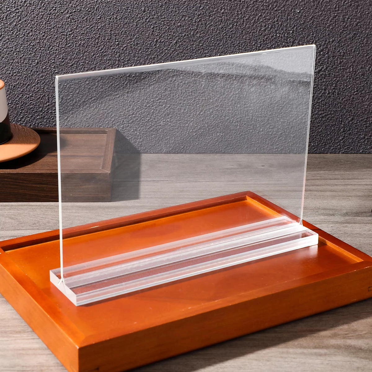 Clear acrylic double-sided tabletop sign holder with an orange wooden base