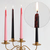 Set of four black and pink taper candles with dripping blood effect displayed on a gold stand.
