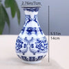 Blue and white ceramic flower vase with intricate floral patterns on a light background.