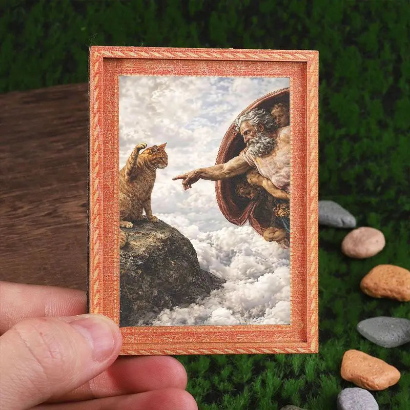 A framed art print featuring a painting of a cat looking out of a bowl against a cloudy sky