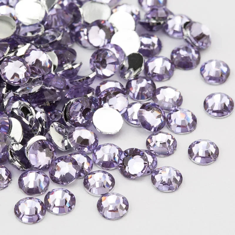 A pile of round flatback resin rhinestones in various shades of purple and silver.