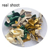 A collection of sage green and gold satin fabric confetti balloons in various shades and sizes.