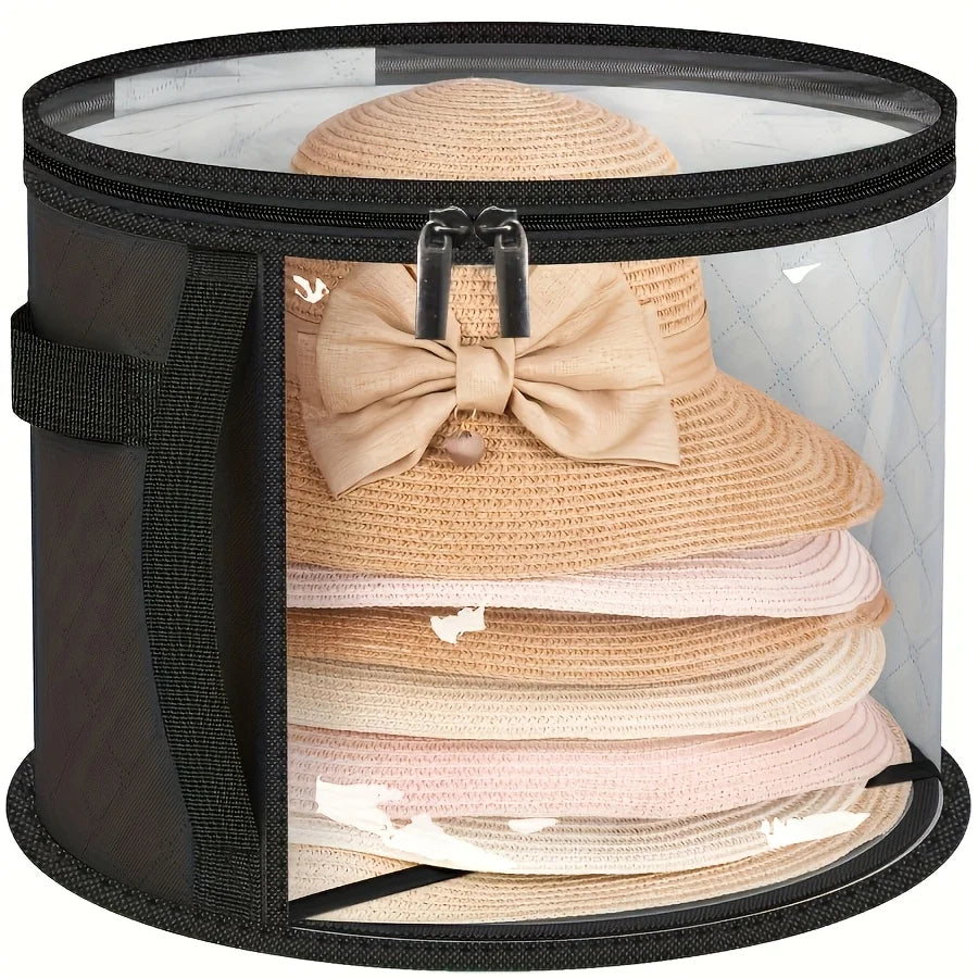 A black storage box with a clear window displaying several beige and pink straw hats stacked inside.