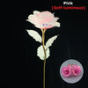 Pink self-luminous rose flower with green leaves on a gold stem