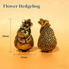 A brass flower hedgehog statue with a textured body and a floral crown, shown against a light background.